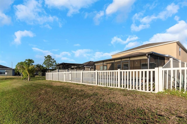 view of yard featuring fence and a sunroom