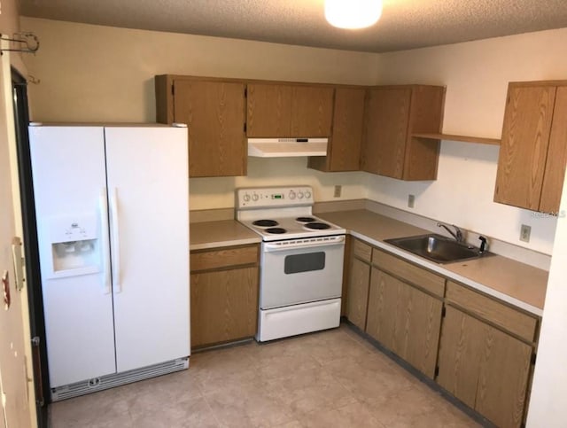 kitchen featuring a sink, light countertops, under cabinet range hood, and white appliances