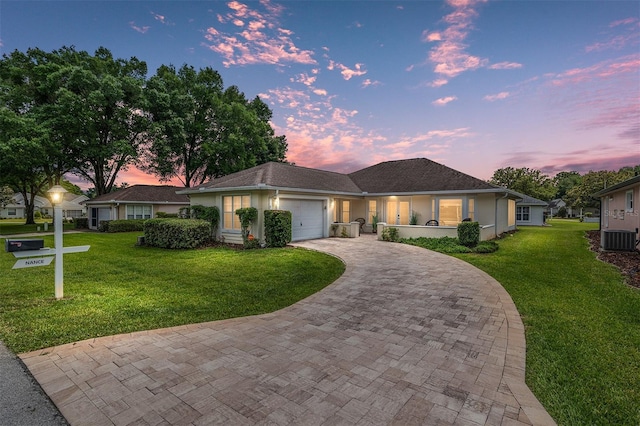6858 SW 111th Loop, Ocala, FL 34476 - ranch-style home featuring a garage, central air condition unit, decorative driveway, and a front yard