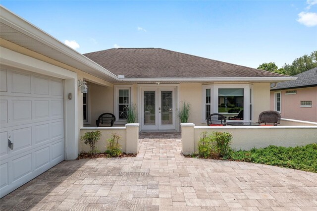 6858 SW 111th Loop, Ocala, FL 34476 - exterior space featuring french doors, stucco siding, an attached garage, and roof with shingles