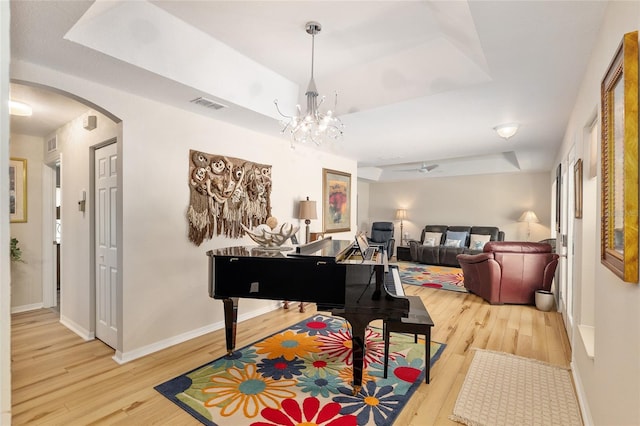 6858 SW 111th Loop, Ocala, FL 34476 - sitting room featuring visible vents, arched walkways, baseboards, light wood finished floors, and a tray ceiling