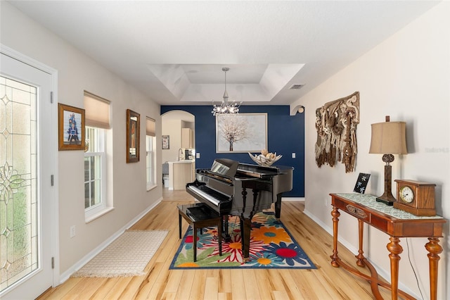 6858 SW 111th Loop, Ocala, FL 34476 - sitting room with baseboards, a tray ceiling, a chandelier, and wood finished floors
