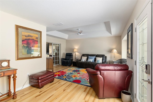 6858 SW 111th Loop, Ocala, FL 34476 - living room featuring ceiling fan, baseboards, wood finished floors, a tray ceiling, and visible vents