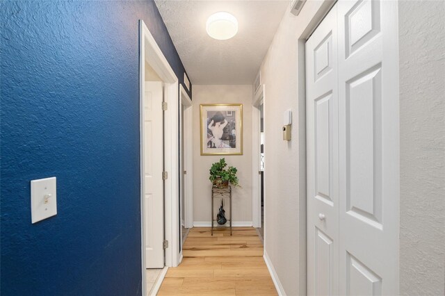6858 SW 111th Loop, Ocala, FL 34476 - hall with a textured wall, baseboards, and light wood-style floors