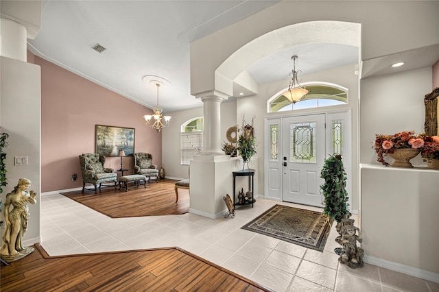 4966 SW 107th Loop, Ocala, FL 34476 - foyer entrance with decorative columns, vaulted ceiling, wood finished floors, a chandelier, and arched walkways