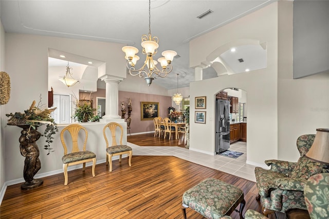 4966 SW 107th Loop, Ocala, FL 34476 - living area with arched walkways, light wood-style floors, a chandelier, ornate columns, and recessed lighting