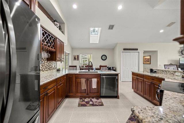 4966 SW 107th Loop, Ocala, FL 34476 - kitchen with appliances with stainless steel finishes, a sink, a skylight, a peninsula, and recessed lighting