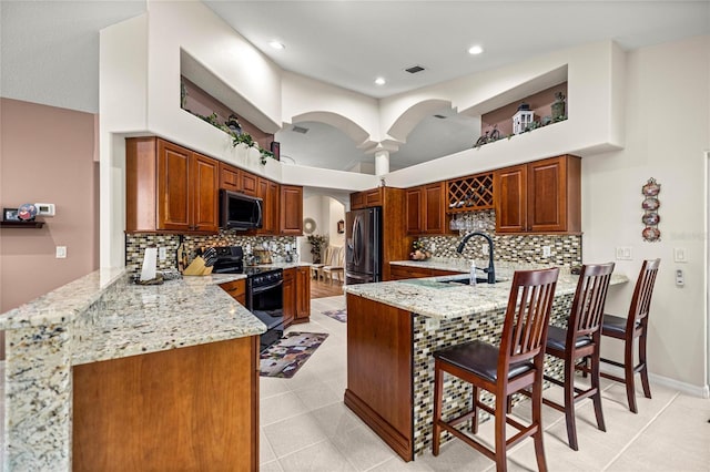 4966 SW 107th Loop, Ocala, FL 34476 - kitchen with black appliances, a sink, a peninsula, arched walkways, and recessed lighting