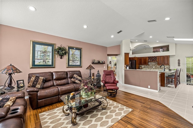 4966 SW 107th Loop, Ocala, FL 34476 - living room with lofted ceiling, light wood-style floors, recessed lighting, and a textured ceiling