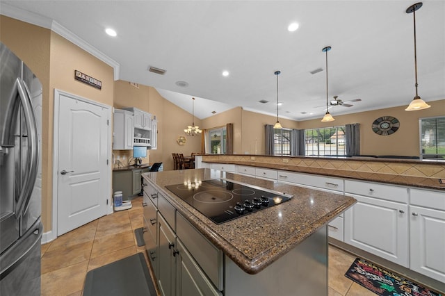 kitchen with a kitchen island, recessed lighting, black electric stovetop, and stainless steel fridge