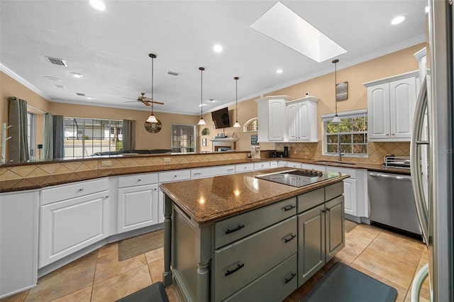 kitchen with decorative backsplash, visible vents, a skylight, a peninsula, and stainless steel appliances