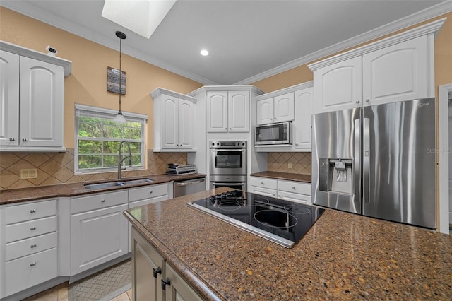 kitchen with crown molding, a sink, stainless steel appliances, decorative light fixtures, and a skylight