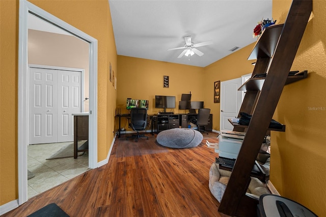 office space featuring baseboards, ceiling fan, visible vents, and wood finished floors