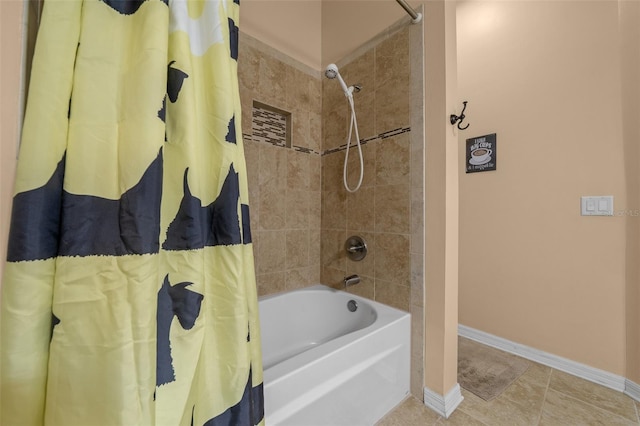 bathroom with baseboards and shower / bathtub combination with curtain