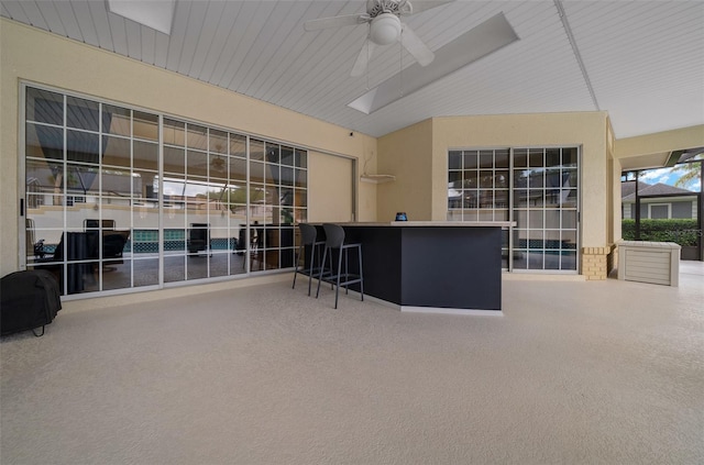 view of patio with outdoor dry bar and a ceiling fan