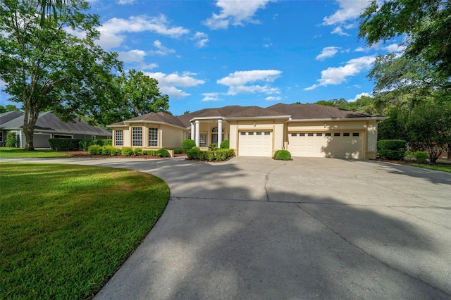 view of front of home with concrete driveway, an attached garage, a front yard, and stucco siding