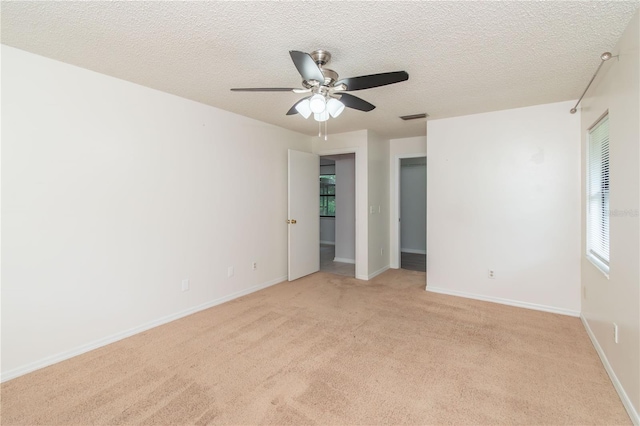 1406 SE Wacahoota Rd, Micanopy, FL 32667 - unfurnished bedroom with light colored carpet, a textured ceiling, ceiling fan, and baseboards