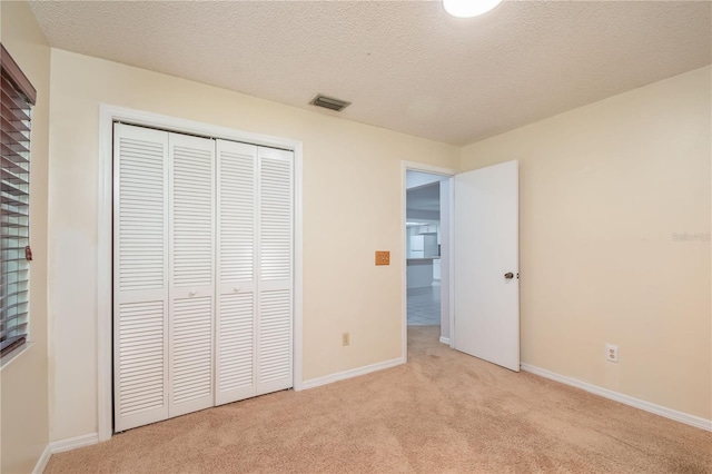 1406 SE Wacahoota Rd, Micanopy, FL 32667 - unfurnished bedroom featuring light colored carpet, a closet, baseboards, and a textured ceiling