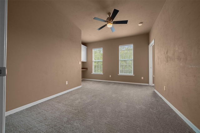 carpeted empty room with baseboards and ceiling fan