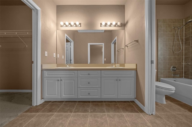 bathroom with a sink, tile patterned flooring, toilet, and double vanity