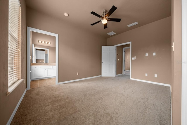 unfurnished bedroom featuring connected bathroom, a sink, visible vents, baseboards, and light colored carpet