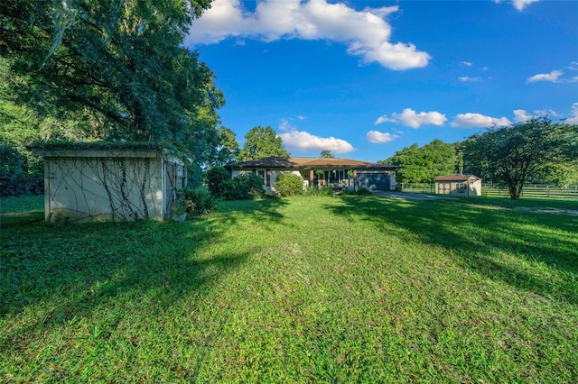 13232 NE 39th Ter, Anthony, FL 32617 - view of yard featuring a storage unit, fence, a garage, and an outbuilding