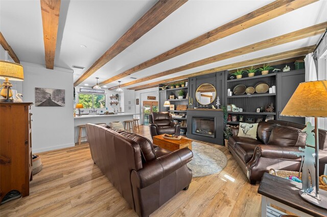 13232 NE 39th Ter, Anthony, FL 32617 - living area with a fireplace, light wood finished floors, beamed ceiling, and baseboards