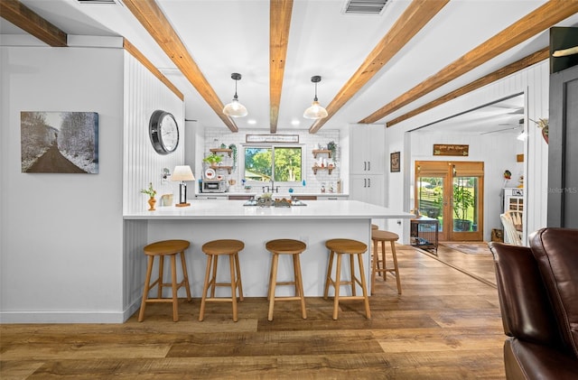 13232 NE 39th Ter, Anthony, FL 32617 - kitchen with a peninsula, wood finished floors, a kitchen breakfast bar, pendant lighting, and beamed ceiling