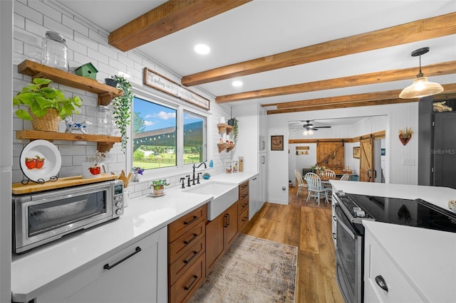 13232 NE 39th Ter, Anthony, FL 32617 - kitchen with light wood-style flooring, a sink, open shelves, beam ceiling, and stainless steel appliances