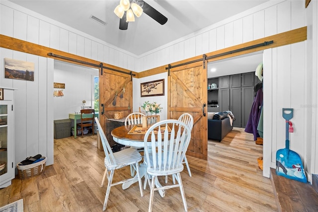 13232 NE 39th Ter, Anthony, FL 32617 - dining room featuring visible vents, a barn door, light wood-style flooring, and ceiling fan