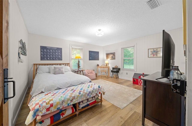 13232 NE 39th Ter, Anthony, FL 32617 - bedroom featuring multiple windows, light wood finished floors, visible vents, and a textured ceiling