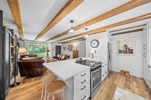 13232 NE 39th Ter, Anthony, FL 32617 - kitchen featuring a peninsula, appliances with stainless steel finishes, white cabinetry, open floor plan, and light wood-style floors