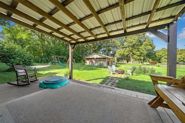 13232 NE 39th Ter, Anthony, FL 32617 - view of patio / terrace featuring an outdoor structure, a wooden deck, a fire pit, and a playground