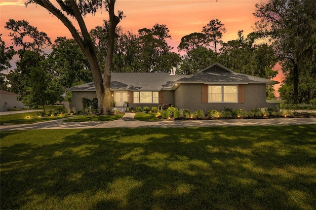 5326 NW 76th Ct, Ocala, FL 34482 - ranch-style house featuring a front yard, stucco siding, roof with shingles, and view of scattered trees