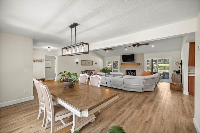 5326 NW 76th Ct, Ocala, FL 34482 - dining space featuring ceiling fan, a fireplace, plenty of natural light, light wood-style flooring, and a textured ceiling