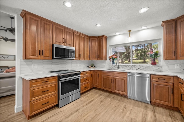 5326 NW 76th Ct, Ocala, FL 34482 - kitchen with appliances with stainless steel finishes, brown cabinetry, a textured ceiling, and recessed lighting
