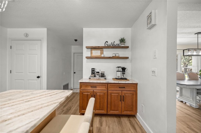 5326 NW 76th Ct, Ocala, FL 34482 - bar area with a textured ceiling, light wood-style flooring, baseboards, and a chandelier