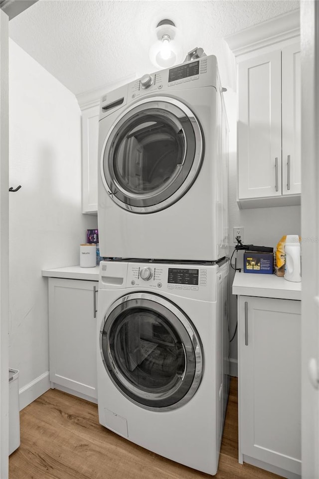 5326 NW 76th Ct, Ocala, FL 34482 - laundry room with estacked washer and dryer, cabinet space, light wood-type flooring, and baseboards
