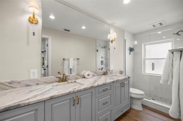 5326 NW 76th Ct, Ocala, FL 34482 - bathroom featuring wood finished floors, a stall shower, double vanity, toilet, and recessed lighting