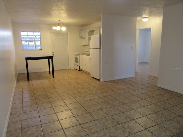 kitchen featuring baseboards, white cabinets, a chandelier, white appliances, and light tile patterned flooring
