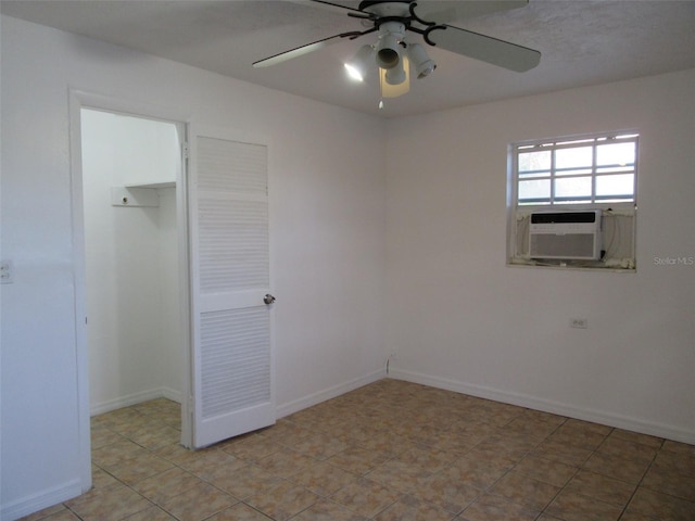 unfurnished bedroom with ceiling fan, baseboards, cooling unit, a closet, and a spacious closet