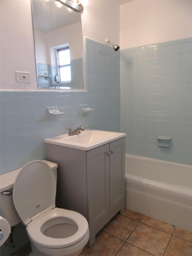 full bath with shower / tub combination, tile patterned flooring, vanity, toilet, and tile walls