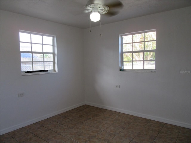unfurnished room with baseboards, ceiling fan, and a wealth of natural light