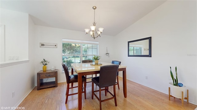 dining room featuring vaulted ceiling, an inviting chandelier, baseboards, and light wood-style floors