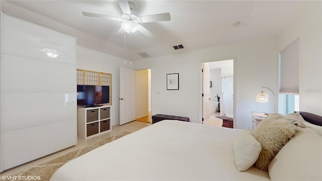 bedroom featuring ensuite bathroom, a ceiling fan, and visible vents