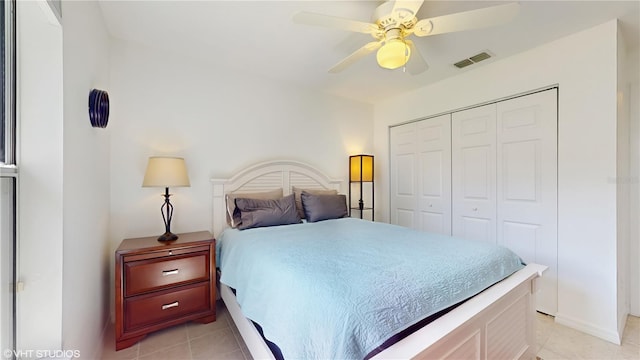bedroom featuring a closet, a ceiling fan, visible vents, and light tile patterned flooring