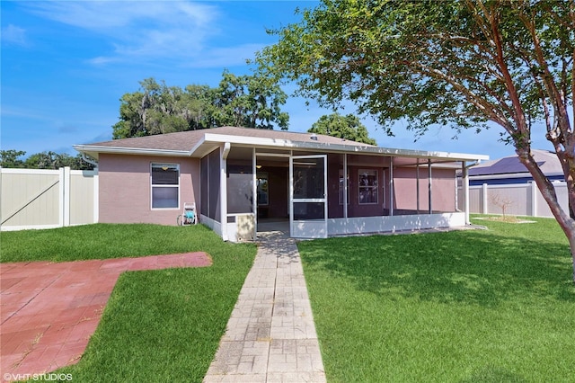 view of front of house with a sunroom, fence, and a front yard