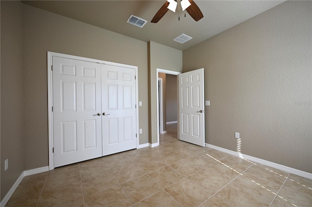 unfurnished bedroom featuring a closet, visible vents, light tile patterned flooring, and ceiling fan