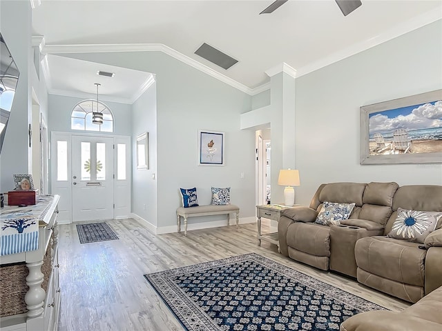 living area with ornamental molding, high vaulted ceiling, light wood-style flooring, a ceiling fan, and baseboards