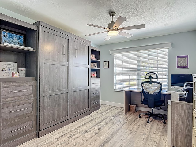 office with light wood finished floors, a textured ceiling, baseboards, and ceiling fan